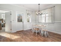 Bright dining room features hardwood floors, a table with chairs, and access to other rooms at 187 Ashley Woods Ct, Clayton, NC 27527