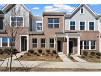 Newly constructed townhomes with a mix of brick and siding and manicured lawns at 284 Chesapeake Commons St # 150, Garner, NC 27529