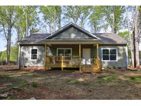 Charming one-story home with a cozy front porch nestled in a wooded lot at 512-A E Graham St, Mebane, NC 27302