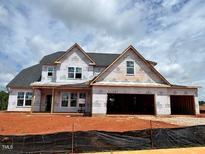 Image of an unfinished two-story home with visible wood framing and a multi-car garage at 66 Tennyson Dr, Garner, NC 27529