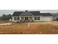 Charming single-story home with a two-car garage and welcoming front porch with brick detailing at 69 N Movado Trl, Kenly, NC 27542