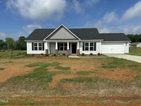Charming single-story home with a welcoming front porch and a two-car garage at 69 N Movado Trl, Kenly, NC 27542