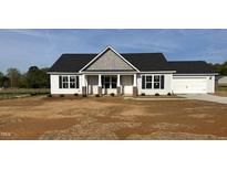 Charming single-story home with black shutters, a gray roof, and a spacious two-car garage at 69 N Movado Trl, Kenly, NC 27542