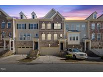 Three story townhouses with attached garages and front landscaping at 8352 Primanti Blvd, Raleigh, NC 27612