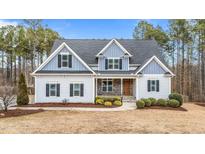 Two-story home with gray siding, gray roof, and landscaping at 1513 Hoke Landing Ln, Raleigh, NC 27603