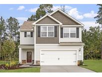 Two-story house with neutral siding, a double garage, and landscaping at 207 Shelfit Trl, Oxford, NC 27565