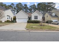 House exterior featuring a two-car garage and well-maintained landscaping at 208 Trailview Dr, Cary, NC 27513