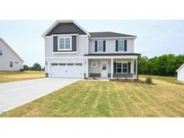 Inviting two-story home featuring a two-car garage and a well-maintained lawn at 223 Johnson Ridge Way, Four Oaks, NC 27524