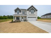 Charming two-story home featuring a covered porch and attached two-car garage at 236 Johnson Ridge Way, Four Oaks, NC 27524