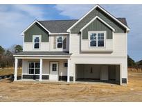 Charming two-story home with a welcoming front porch and an attached two-car garage at 236 Johnson Ridge Way, Four Oaks, NC 27524