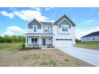 Charming two-story home with a two-car garage, landscaped front yard, and covered front porch entrance at 236 Johnson Ridge Way, Four Oaks, NC 27524