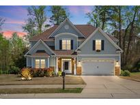 Charming two-story home with a manicured lawn, a two-car garage, and beautiful landscaping at 347 Country Mill Way, Fuquay Varina, NC 27526