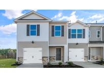 Two-story townhome with gray siding, white garage doors, and landscaping at 408 Honeycutt Oaks Dr, Angier, NC 27501