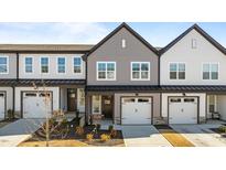 Charming townhome showcasing a well-manicured lawn, attached garage, and craftsman-style details at 608 Marshskip Way, Rolesville, NC 27587