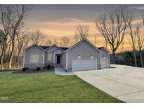 Charming one-story home boasts a large driveway and an attached two-car garage at 620 Rollins Mill Rd, Holly Springs, NC 27540