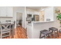 Well-lit kitchen features stainless steel appliances, granite countertops, and breakfast bar with seating at 620 Rollins Mill Rd, Holly Springs, NC 27540