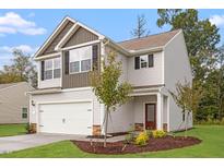 Two-story house with attached garage, landscaping, and a neutral color palette at 815 Rhino Bnd, Oxford, NC 27565