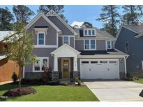 Charming two-story home with gray siding, stone accents, a yellow front door and an attached two-car garage at 9164 Dupree Meadow Dr # 14, Angier, NC 27501