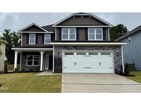 Charming two-story home with a gray stone base, two-car garage, and a well-manicured front lawn at 111 Southern Estates Dr, Sanford, NC 27330
