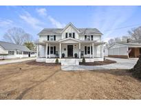 Charming two-story farmhouse-style home with a covered front porch and classic black shutters at 210 W Oak Ave, Wake Forest, NC 27587