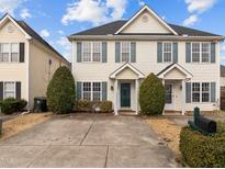 Two-story townhome with light beige siding, gray shutters, and a shared driveway at 2321 Turtle Point Dr, Raleigh, NC 27604