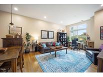 Bright living room featuring a leather sofa, wood furniture, and a blue area rug for a cozy, inviting atmosphere at 317 W Morgan Street # 405, Raleigh, NC 27601