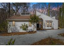 Charming exterior view of a modern home with unique architectural details and fresh, white siding with well-maintained landscaping at 5709 Russell Rd, Durham, NC 27712