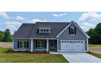 Charming one-story home featuring a two-car garage, black shutters and a well-manicured lawn at 6294 River Rd, Fuquay Varina, NC 27526
