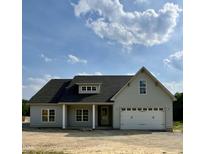 Beautiful single-story home with gray siding, dark roof, and a welcoming two-car garage under a partly cloudy sky at 6294 River Rd, Fuquay Varina, NC 27526
