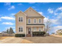Two-story house with beige siding, brick accents, and a landscaped yard at 101 Haywood Ln, Clayton, NC 27527