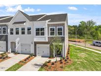 New construction townhomes with attached garages and professionally landscaped front yards at 104 Central Townes Way # 296, Raleigh, NC 27603