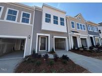 Charming townhome with a two-car garage and beautifully manicured front yard at 111 Central Townes Way # 299, Raleigh, NC 27603