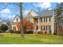 Two-story brick home with a large front yard and a red door at 112 Gingergate Dr, Cary, NC 27519
