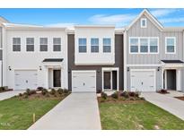 New construction townhome showcasing a modern facade, attached garages, and manicured lawns at 144 Fideaux Blvd # 251, Raleigh, NC 27603