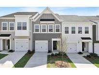 Townhome exterior featuring multi-car garage, well-manicured lawn, and neutral color palette at 152 Fideaux Blvd # 249, Raleigh, NC 27603