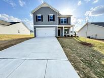 Charming two-story home with gray siding, black shutters, and a long driveway at 154 Vega Loop, Sanford, NC 27330
