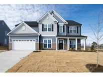 Two-story house with gray siding, white garage door, and landscaping at 30 Rosewood Ln, Youngsville, NC 27596