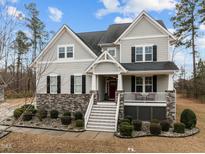 Charming two-story home with a stone-accented facade, inviting front porch, and manicured landscaping at 3308 Eden Grove Rd, Fuquay Varina, NC 27526
