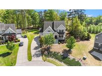 Beautiful home exterior with a well-manicured lawn, mature trees, and a long driveway at 3308 Eden Grove Rd, Fuquay Varina, NC 27526