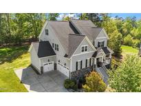 An upscale two-story home featuring a 2-car garage and a beautifully landscaped yard with trees at 3308 Eden Grove Rd, Fuquay Varina, NC 27526