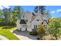 Beautiful home exterior with gray siding, stone accents, a well-maintained lawn, and an attached two car garage at 3308 Eden Grove Rd, Fuquay Varina, NC 27526