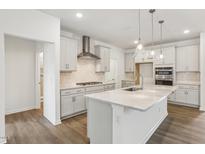 Modern kitchen with island, stainless steel appliances, and white cabinetry at 4408 Emeline Way # 34, Fuquay Varina, NC 27526