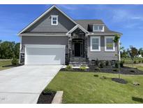 Charming home features a two-car garage, stone accents, landscaped yard, and welcoming front entry at 82 N Stagecoach Dr, Wendell, NC 27591