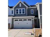 Two-story home with gray siding, white garage doors, and a landscaped yard at 8947 Kennebec Crossing Dr # 53, Angier, NC 27501