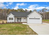 Charming white home with a two-car garage, a cozy front porch, and a well-maintained lawn at 9342 Turkey Way, Middlesex, NC 27557