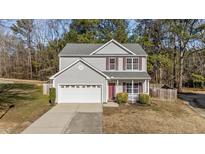 Charming two-story home with grey siding, red shutters, and a two-car garage at 1305 Turks Head Ct, Zebulon, NC 27597
