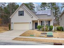 House exterior with solar panels, a two-car garage, and well-manicured landscaping at 131 Kinnakeet Dr, Durham, NC 27704