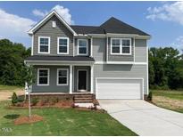 Charming two-story home featuring a well-manicured lawn and a classic architectural design at 139 Grove Township Way, Angier, NC 27501