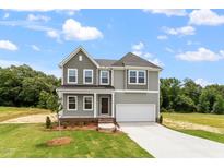 Inviting two-story home with gray siding, a two-car garage, and a well-manicured front yard at 139 Grove Township Way, Angier, NC 27501
