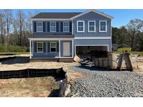 New two story home with blue siding, covered porch, and attached garage at 157 Grove Township Way, Angier, NC 27501